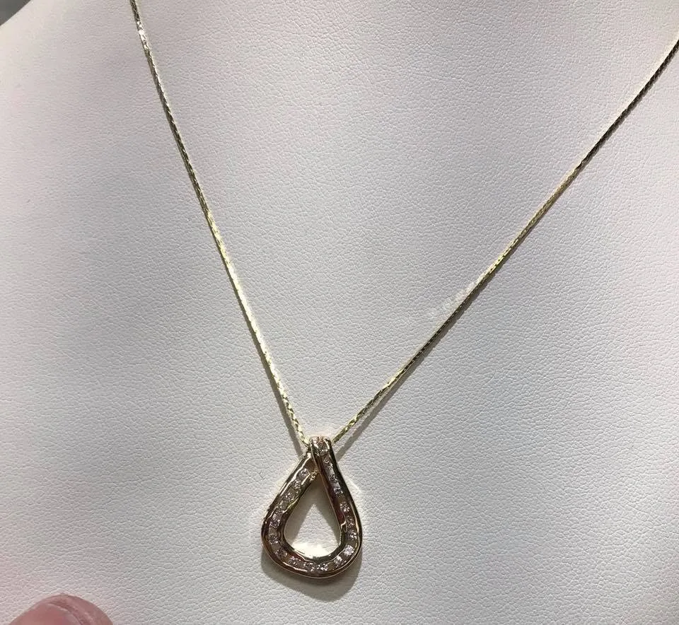 Yellow gold teardrop pendant with channel-set diamonds on a fine box chain