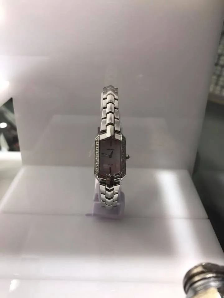Ladies' two-tone rectangular dial bracelet watch on a display stand