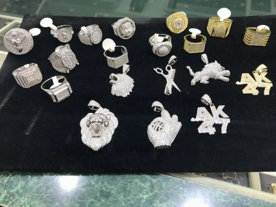 Men's gold and silver rings and pendants laid out on black velvet