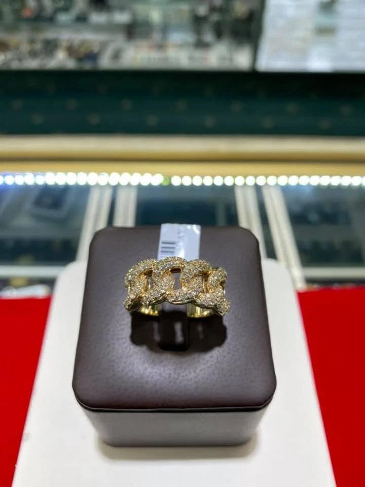Yellow gold pavé Cuban link ring on a brown leather ring display