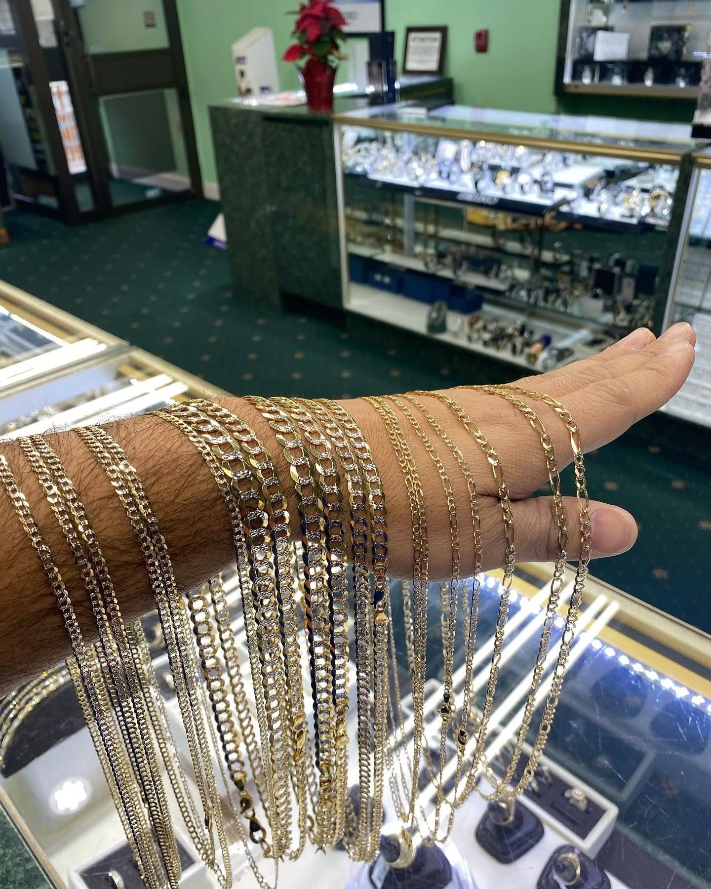 Gold Cuban and Figaro chains displayed over the jewelry cases at the Capital Jewelry showroom in Trenton, NJ