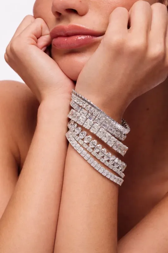 Stack of diamond tennis bracelets in emerald, round and baguette cuts worn on the wrist