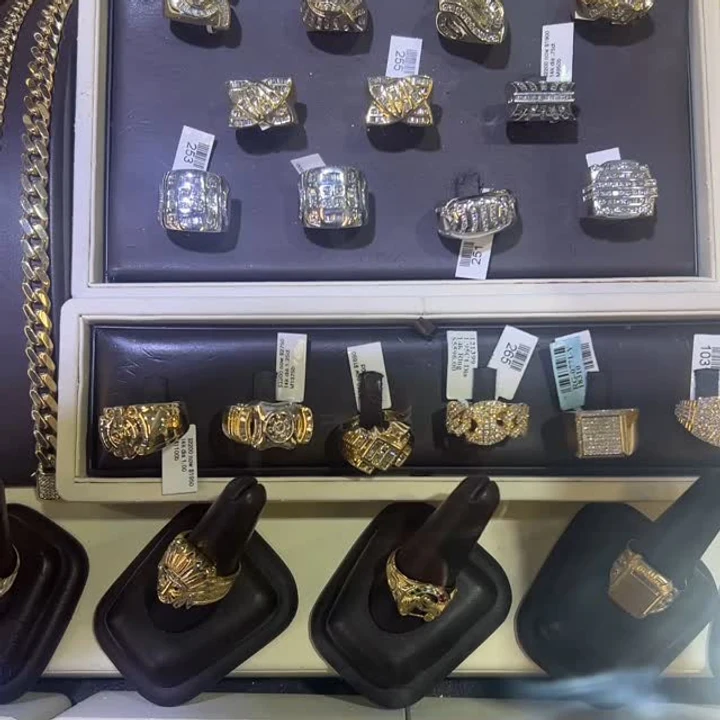 Men's gold and diamond rings lined up in the Capital Jewelry display case