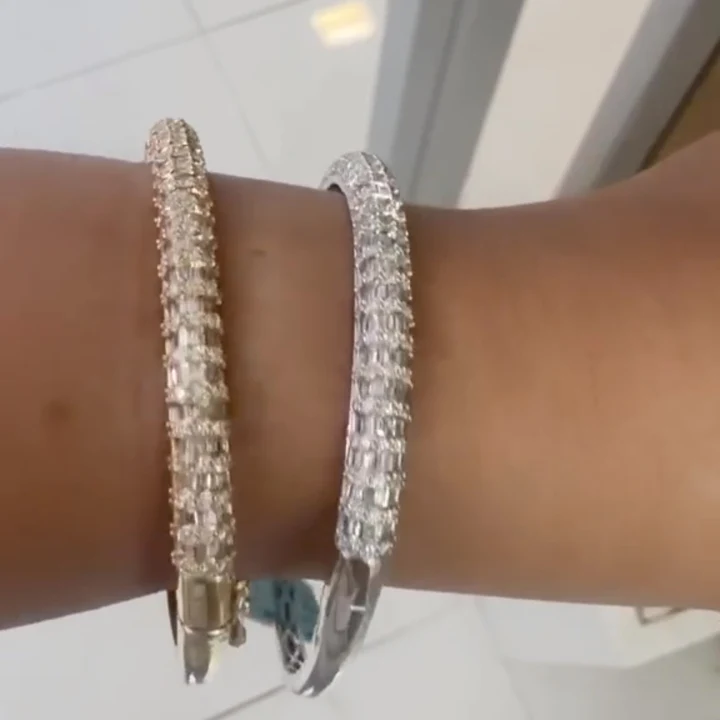 Two diamond bangle bracelets in yellow and white gold worn on the wrist