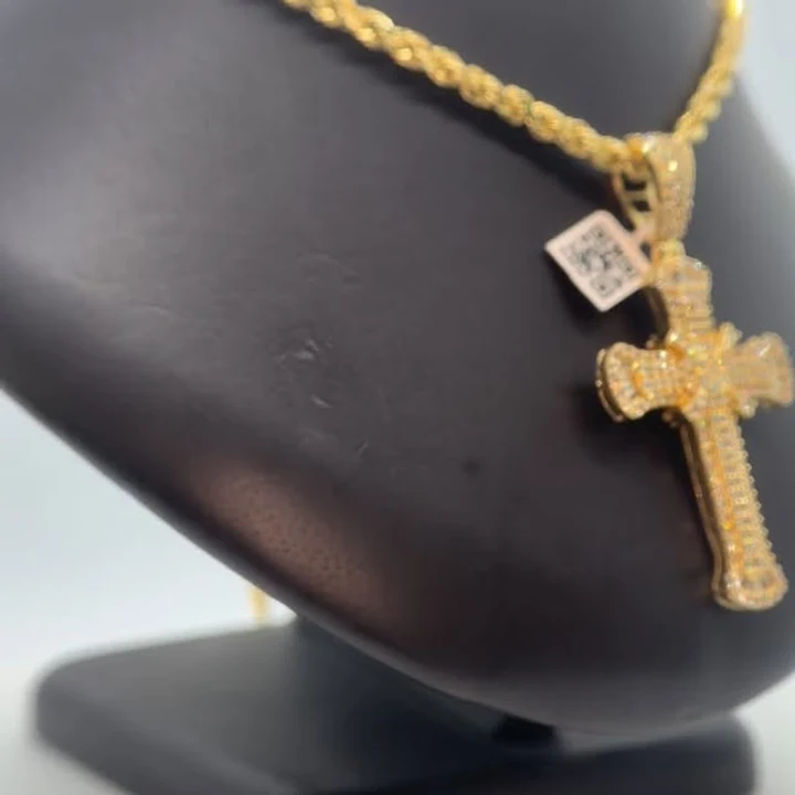 Gold rope chain with a diamond cross pendant on a black display bust