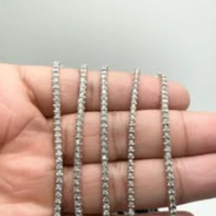 Diamond tennis chains draped across an open hand